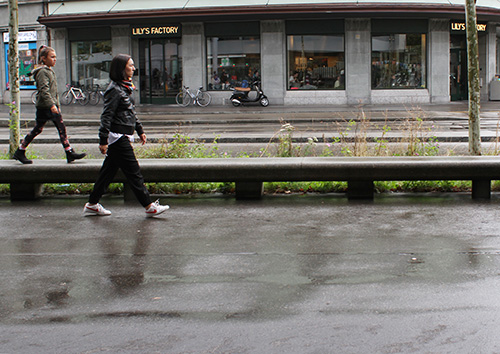 mother and child walking in front of a street parallel